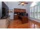 Functional home office with custom wood built-ins, a desk, and large windows offering natural light at 8008 Alba Ct, Charlotte, NC 28269