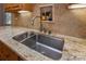 A close-up of a stainless-steel kitchen sink features a gooseneck faucet and granite countertops at 8008 Alba Ct, Charlotte, NC 28269