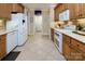 This kitchen features light-colored tile floors, countertops and wood cabinets with white appliances at 8008 Alba Ct, Charlotte, NC 28269