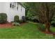 Beautiful landscaping features a well manicured yard with lush greenery and mulch accents beside a white house at 8008 Alba Ct, Charlotte, NC 28269