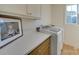 Functional laundry room with counter space, storage, and a bright window at 8039 Mcconnell Rd, Denver, NC 28037
