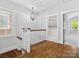 Well-lit hallway with hardwood floors, a decorative chandelier, and access to a kitchen area at 807 Herrons Ferry Rd, Rock Hill, SC 29730