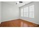 Bright bedroom with hardwood floors, ceiling fan, and large windows for plenty of natural light at 8230 Viewpoint Ln, Cornelius, NC 28031