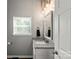 Bright bathroom with granite countertop, fresh gray paint, and a modern mirror above the sink at 85 Ruritan Park Rd, Stony Point, NC 28678