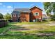 Back exterior of brick home featuring grassy yard, patio furniture, and an AC unit at 85 Ruritan Park Rd, Stony Point, NC 28678