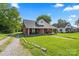 Traditional brick home with a lush, green lawn and a quaint, tree-lined neighborhood setting at 85 Ruritan Park Rd, Stony Point, NC 28678