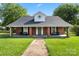 Charming brick home featuring a covered porch, black shutters and a beautifully maintained lawn at 85 Ruritan Park Rd, Stony Point, NC 28678