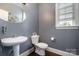 Powder room features modern fixtures, pedestal sink, and neutral gray walls at 9032 Cornflower Dr, Harrisburg, NC 28075