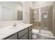Bathroom features gray vanity with stone countertop and glass enclosed shower at 9032 Cornflower Dr, Harrisburg, NC 28075