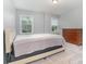 Bedroom featuring light blue walls, plush carpeting, two windows, and a wooden dresser at 9032 Cornflower Dr, Harrisburg, NC 28075