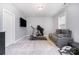 Bonus Room with neutral walls, beige carpeting, television and workout equipment, and comfortable couch at 9032 Cornflower Dr, Harrisburg, NC 28075