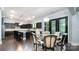Dining room features a modern chandelier and dark wood floors adjacent to kitchen at 9032 Cornflower Dr, Harrisburg, NC 28075