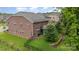 Aerial view of a fenced backyard with a retaining wall, screened porch and brick exterior home at 9032 Cornflower Dr, Harrisburg, NC 28075