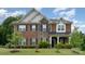 Charming two-story home featuring a mix of brick and stone exterior with a well-manicured front yard at 9032 Cornflower Dr, Harrisburg, NC 28075