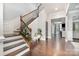Grand foyer featuring a hardwood floor, staircase with decorative railing, and elegant lighting at 9032 Cornflower Dr, Harrisburg, NC 28075