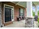 Inviting front porch with brick accents, stone pillars, and comfortable seating at 9032 Cornflower Dr, Harrisburg, NC 28075