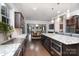 Open kitchen showcases granite counters, dark wood cabinets, and view to dining area at 9032 Cornflower Dr, Harrisburg, NC 28075