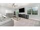 Living room features ceiling fan, large windows, and comfortable gray couches at 9032 Cornflower Dr, Harrisburg, NC 28075
