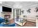 Bright living room featuring a stone fireplace, hardwood floors, and comfortable seating at 9032 Cornflower Dr, Harrisburg, NC 28075
