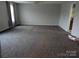 Large living room with neutral carpeting and a view of the kitchen through an open door at 936 New Camp Creek Church Rd # 11, Kings Mountain, NC 28086