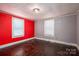 Simple bedroom with hard wood floors, two windows providing natural light, and painted accent wall at 1070 Nc 182 Hwy, Lincolnton, NC 28092