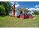 Quaint home featuring brick foundation, covered porch, mature trees, and well-maintained lawn at 1070 Nc 182 Hwy, Lincolnton, NC 28092