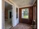 The image showcases a charming sunroom featuring wood paneled walls and lots of natural light at 1070 Nc 182 Hwy, Lincolnton, NC 28092