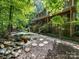 Relaxing backyard featuring a water feature, stone pathway, and views of the tree-lined property at 10710 Bristlecone Ct, Mint Hill, NC 28227