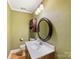 Cozy half bath with a round mirror, updated fixtures, and a green accent wall at 10710 Bristlecone Ct, Mint Hill, NC 28227