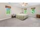 Bright bedroom with a floral bedspread and three windows showcasing the trees outside at 10710 Bristlecone Ct, Mint Hill, NC 28227