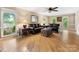 Bright living room featuring hardwood floors, large windows, and a leather sofa set at 10710 Bristlecone Ct, Mint Hill, NC 28227