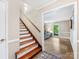 Inviting staircase with hardwood steps adjacent to an open living room at 10710 Bristlecone Ct, Mint Hill, NC 28227