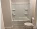 Bathroom features a full tub-shower with built-in shelving, and a modern toilet at 108 Red Juniper Way, Statesville, NC 28625