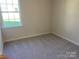 A cozy bedroom with a large window offering natural light and a fresh, neutral palette at 108 Red Juniper Way, Statesville, NC 28625