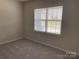 A bright bedroom with neutral carpeting and a large window for natural light at 108 Red Juniper Way, Statesville, NC 28625