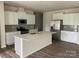 Modern kitchen with white cabinetry, stainless steel appliances, and a large center island with quartz countertop at 108 Red Juniper Way, Statesville, NC 28625