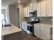 Well-equipped kitchen with white cabinetry, stainless steel oven and microwave, and stylish gray backsplash at 108 Red Juniper Way, Statesville, NC 28625