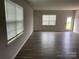 Bright living room with wood-look flooring, white walls, and windows providing ample natural light at 108 Red Juniper Way, Statesville, NC 28625