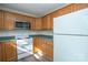 Well-lit kitchen features stainless steel microwave, wooden cabinets, and white appliances at 1083 Elljoy Ln, Salisbury, NC 28146