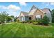 Attractive blue, stone, and beige home with manicured lawn and established landscaping at 10903 Skymont Dr, Huntersville, NC 28078