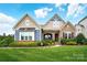 Charming two-story home with a beautifully landscaped yard and stone and siding facade at 10903 Skymont Dr, Huntersville, NC 28078