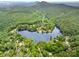 Breathtaking aerial view of a lake community nestled in lush green surroundings with a mountain backdrop at 1102 Lake Montonia Rd, Kings Mountain, NC 28086