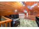 Rustic finished attic featuring wood paneling, built-in shelving, and cozy seating area overlooking the lower level at 1102 Lake Montonia Rd, Kings Mountain, NC 28086