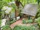 Back exterior with a brick patio, deck, carport, and an outdoor generator surrounded by green landscape at 1102 Lake Montonia Rd, Kings Mountain, NC 28086