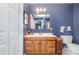Bathroom with a wooden vanity, toilet, and blue wallpaper, offering a functional design at 1102 Lake Montonia Rd, Kings Mountain, NC 28086