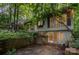 Charming exterior with wooded surroundings, large windows, and patio space at 1102 Lake Montonia Rd, Kings Mountain, NC 28086