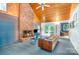 Cozy living room showcasing a striking brick fireplace, vaulted wood ceilings, and glass doors to the deck at 1102 Lake Montonia Rd, Kings Mountain, NC 28086