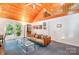Cozy living room with wood-paneled ceiling, loft access, and sliding glass doors to outdoor space at 1102 Lake Montonia Rd, Kings Mountain, NC 28086