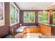 Bright sunroom with large windows offering views, custom built-in seating, and a countertop bar area at 1102 Lake Montonia Rd, Kings Mountain, NC 28086