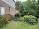 Landscaped backyard featuring lush greenery, a black metal fence, and a wooden deck at 1124 Greenbridge Dr, Matthews, NC 28105